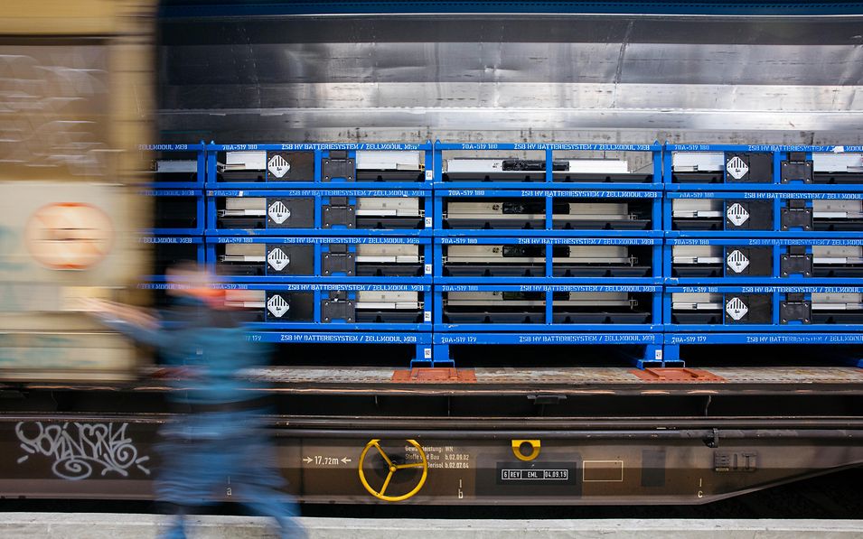 A view inside an open sliding-wall wagon, showing batteries arranged in racks