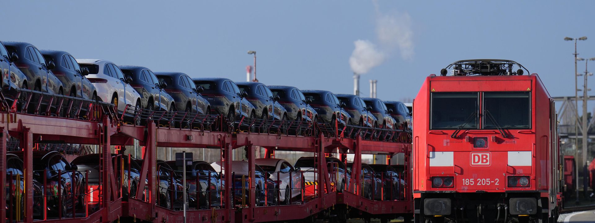  A DB Cargo locomotive alongside a freight train carrying finished vehicles